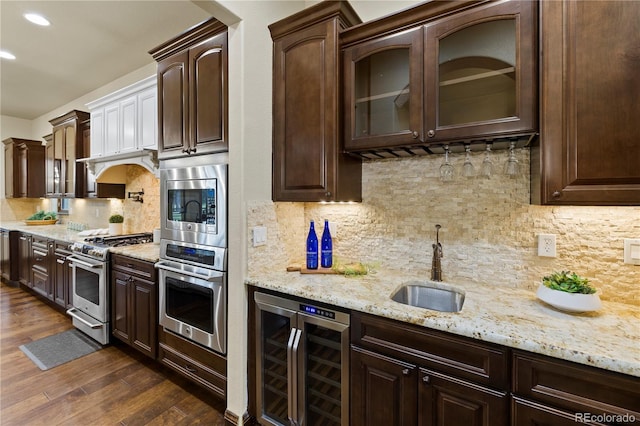 16104 Pole Pine Pt, Colorado Springs, CO 80908 - kitchen with beverage cooler, stainless steel appliances, dark brown cabinetry, dark wood-style floors, and decorative backsplash