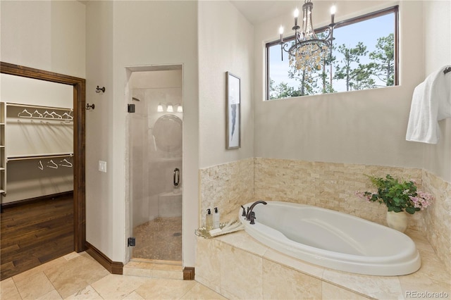 16104 Pole Pine Pt, Colorado Springs, CO 80908 - full bath with a stall shower, a bath, a walk in closet, and a chandelier