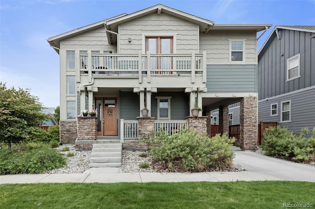 8464 E 55th Pl, Denver, CO 80238 - view of front of home featuring a balcony, stone siding, and covered porch