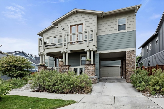 8464 E 55th Pl, Denver, CO 80238 - view of front facade featuring a balcony, a porch, concrete driveway, an attached garage, and stone siding