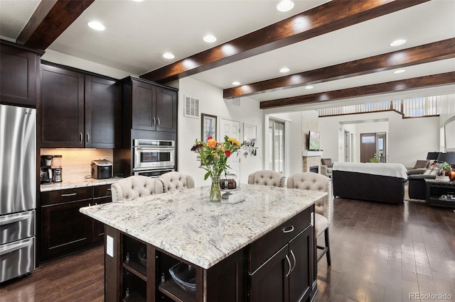 8464 E 55th Pl, Denver, CO 80238 - kitchen featuring stainless steel appliances, beam ceiling, a kitchen bar, open floor plan, and dark wood-style flooring