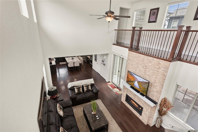 8464 E 55th Pl, Denver, CO 80238 - living room featuring wood finished floors, ceiling fan, a fireplace, and a high ceiling