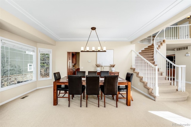 carpeted dining room featuring visible vents, stairs, and baseboards