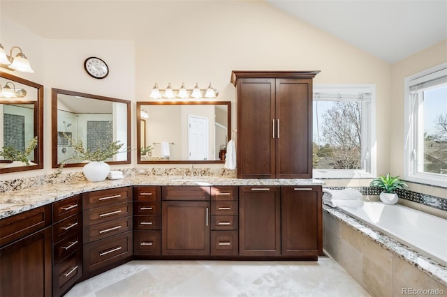 bathroom featuring vanity, a garden tub, and vaulted ceiling