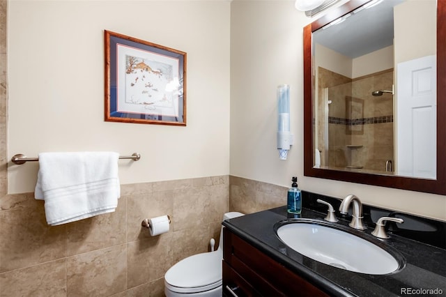 bathroom featuring vanity, tile walls, a shower stall, and toilet