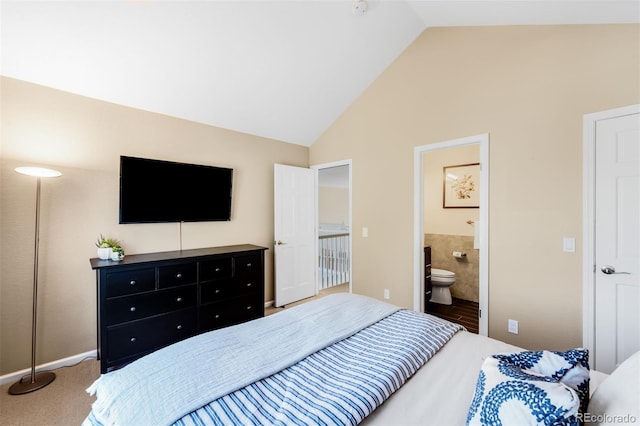 bedroom with carpet flooring, ensuite bathroom, and vaulted ceiling