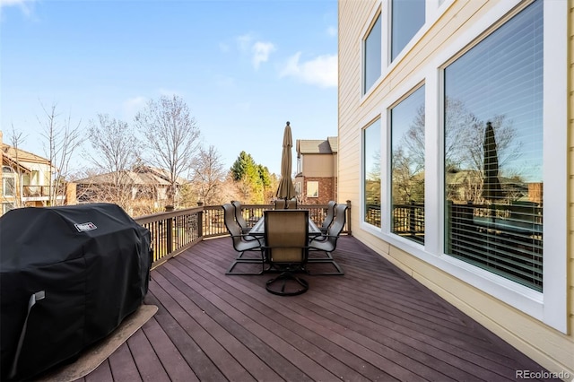 wooden deck with outdoor dining space and a grill