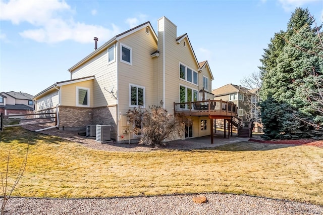 back of property with a lawn, stairway, a wooden deck, central AC unit, and a patio area