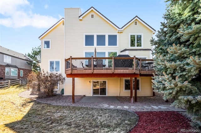 back of house with fence, a deck, a chimney, and a patio area