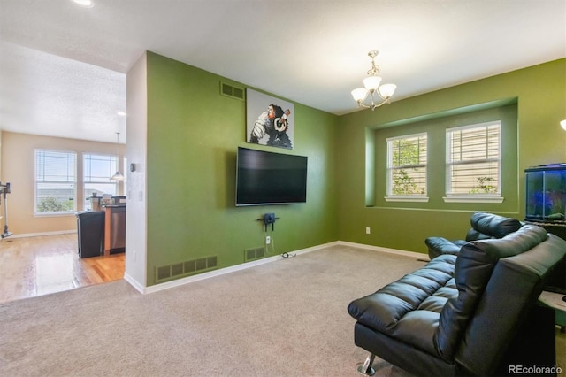 living room featuring a chandelier, carpet floors, and plenty of natural light