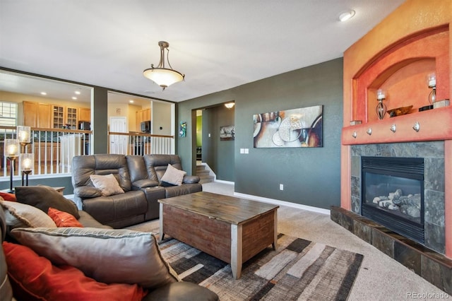 living room featuring a tile fireplace and carpet