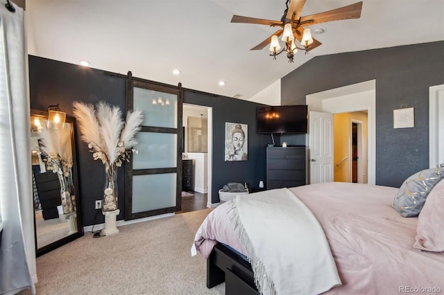 carpeted bedroom with ceiling fan, a barn door, lofted ceiling, and connected bathroom