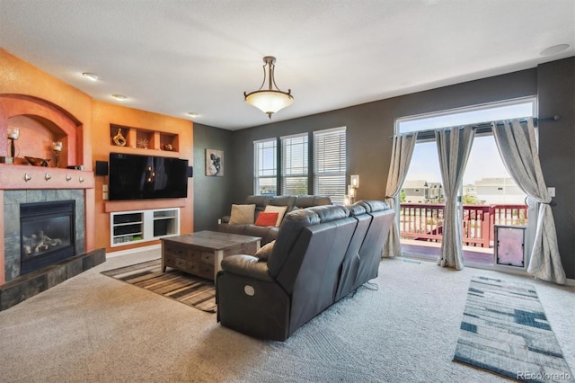 carpeted living room with a textured ceiling and a fireplace