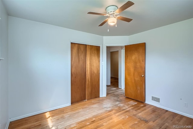 unfurnished bedroom featuring baseboards, a closet, light wood-style flooring, and visible vents