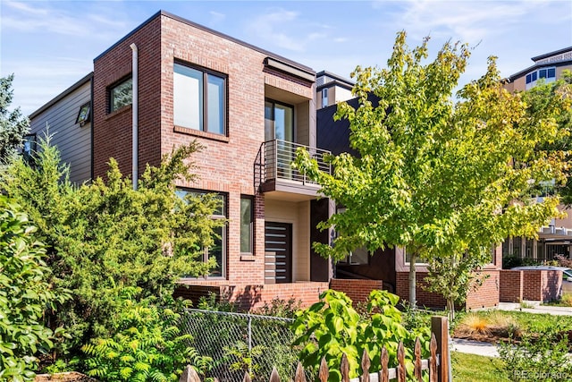 contemporary house with brick siding and a balcony