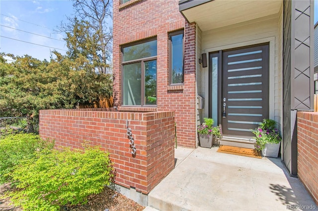 entrance to property featuring brick siding