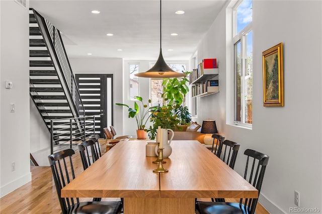 dining area with stairs, a healthy amount of sunlight, recessed lighting, and wood finished floors