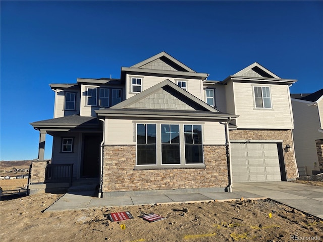 view of front of house featuring a garage, stone siding, and driveway