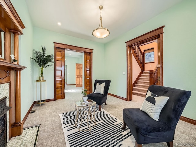 living area with baseboards, stairs, visible vents, and a tiled fireplace