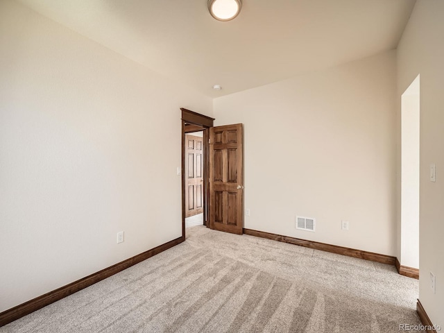 unfurnished room with carpet floors, visible vents, and baseboards