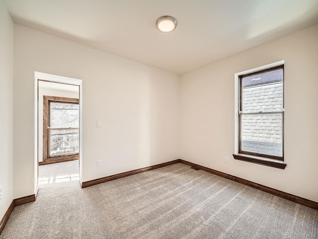 carpeted empty room with baseboards