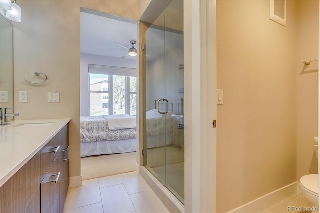 bathroom featuring tile patterned floors, toilet, a shower with shower door, vanity, and ceiling fan