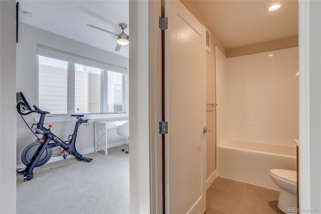 bathroom with toilet, tiled shower / bath combo, tile patterned floors, and ceiling fan