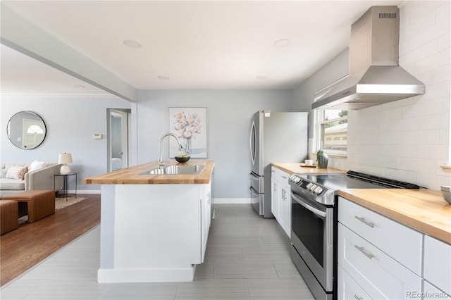 8240 Grandview Ave, Arvada, CO 80002 - kitchen with wooden counters, wall chimney range hood, a sink, appliances with stainless steel finishes, and open floor plan