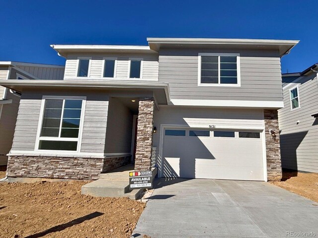 view of front of home with stone siding, concrete driveway, and an attached garage