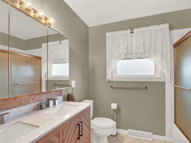bathroom with a sink, visible vents, toilet, and an enclosed shower