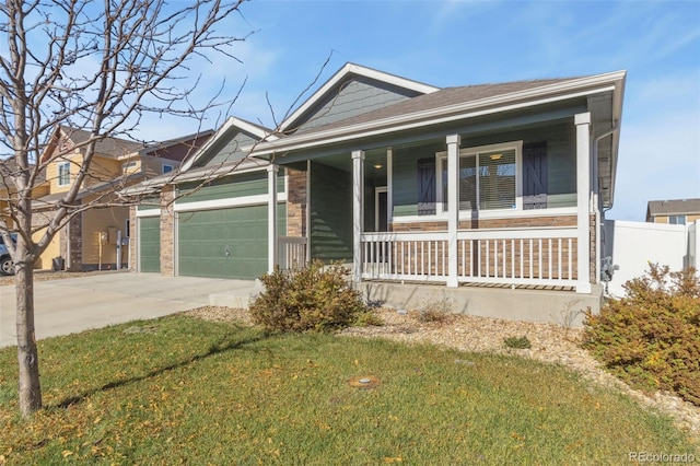 view of front of property with covered porch, a garage, and a front yard