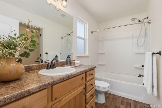 full bathroom featuring hardwood / wood-style flooring, vanity, shower / bathtub combination, and toilet