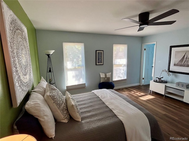 bedroom featuring multiple windows, dark hardwood / wood-style flooring, and ceiling fan