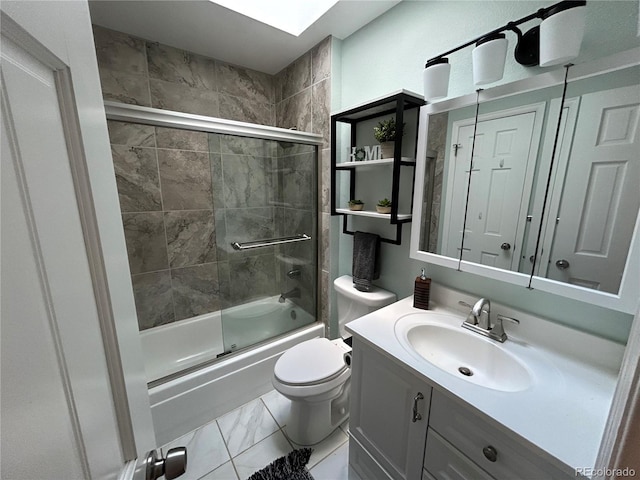 full bathroom featuring vanity, combined bath / shower with glass door, tile patterned flooring, and toilet