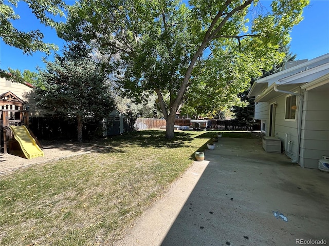 view of yard with a playground, a shed, and a patio area