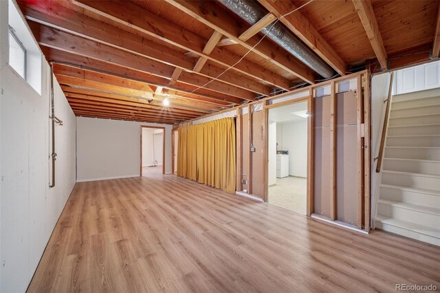 basement with light wood-type flooring and washer / clothes dryer