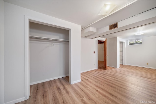 unfurnished bedroom featuring light hardwood / wood-style floors and a closet