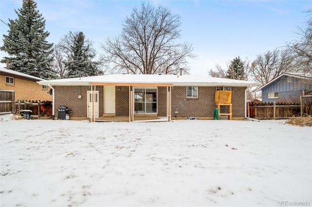 view of snow covered rear of property