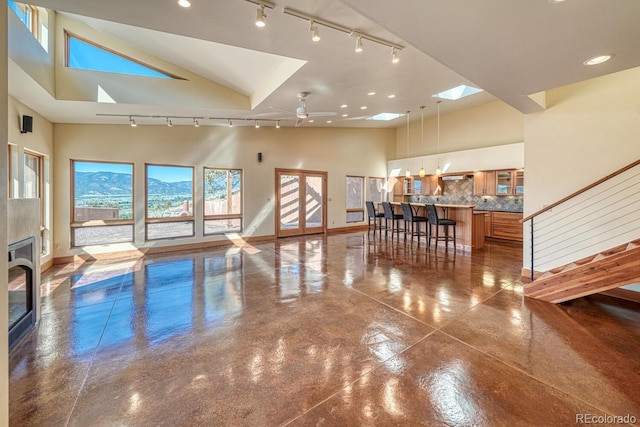 10405 W Cherokee Dr, Salida, CO 81201 - living room featuring rail lighting, high vaulted ceiling, finished concrete floors, a skylight, and recessed lighting