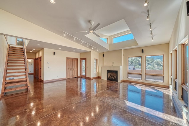 10405 W Cherokee Dr, Salida, CO 81201 - unfurnished living room with rail lighting, a fireplace, ceiling fan, plenty of natural light, and lofted ceiling