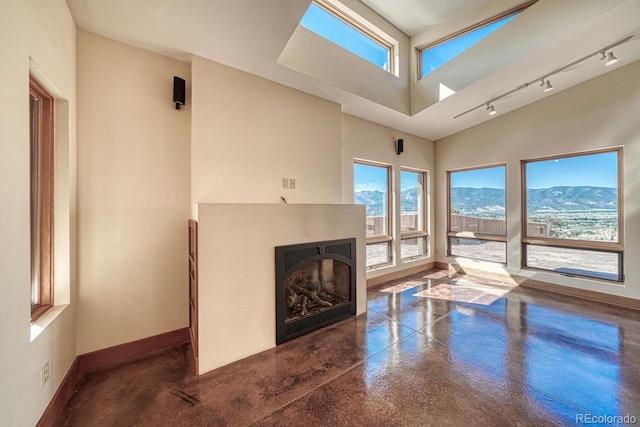 10405 W Cherokee Dr, Salida, CO 81201 - unfurnished living room featuring a fireplace, plenty of natural light, track lighting, and a mountain view