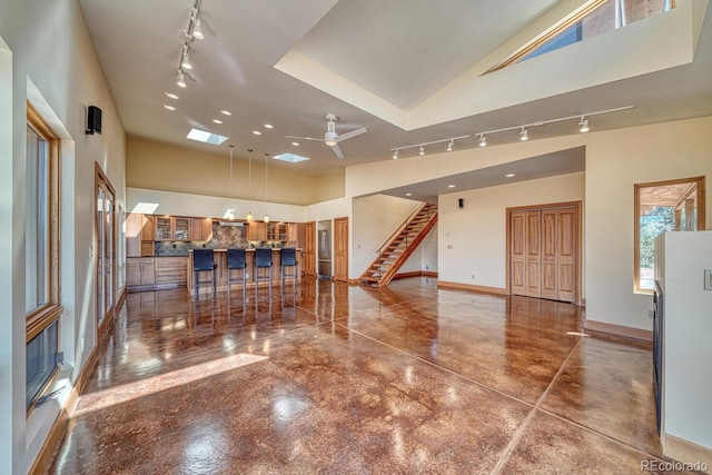 10405 W Cherokee Dr, Salida, CO 81201 - entryway featuring rail lighting, ceiling fan, a high ceiling, finished concrete flooring, and stairs