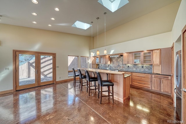 10405 W Cherokee Dr, Salida, CO 81201 - kitchen with a skylight, high vaulted ceiling, a kitchen bar, backsplash, and freestanding refrigerator