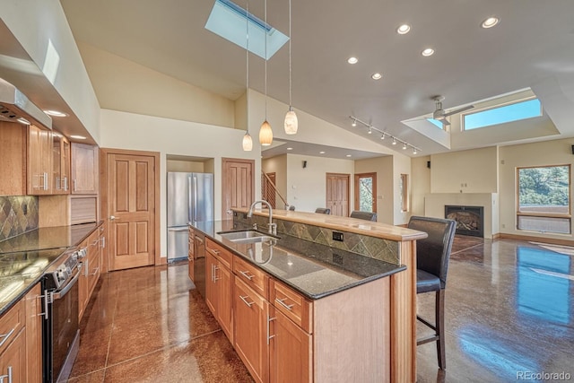 10405 W Cherokee Dr, Salida, CO 81201 - kitchen with appliances with stainless steel finishes, a kitchen breakfast bar, a skylight, an island with sink, and recessed lighting