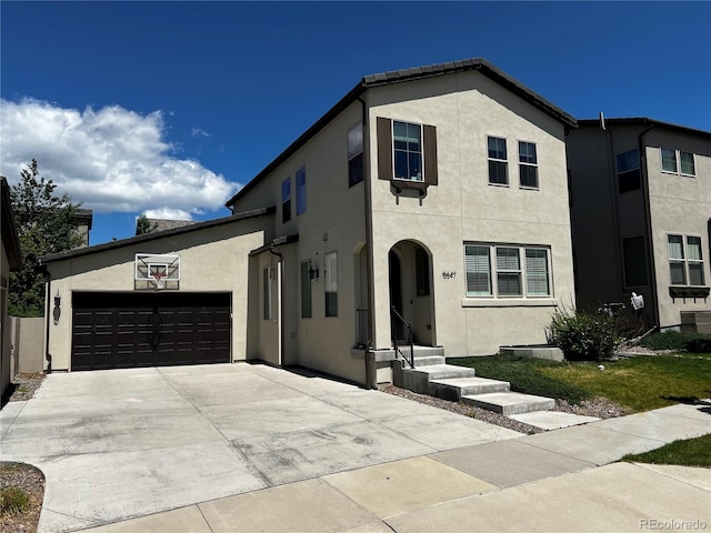 15547 W Vassar Ave, Lakewood, CO 80228 - view of front of property with stucco siding, an attached garage, and driveway