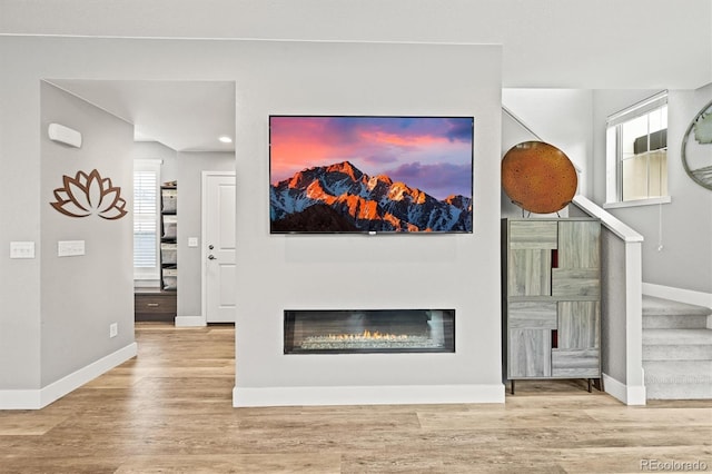 15547 W Vassar Ave, Lakewood, CO 80228 - unfurnished living room with stairway, wood finished floors, recessed lighting, and a glass covered fireplace