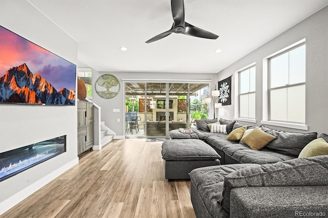 15547 W Vassar Ave, Lakewood, CO 80228 - living area featuring wood finished floors, ceiling fan, stairs, a glass covered fireplace, and recessed lighting