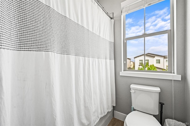 15547 W Vassar Ave, Lakewood, CO 80228 - bathroom featuring healthy amount of natural light, wood finished floors, and a shower with curtain