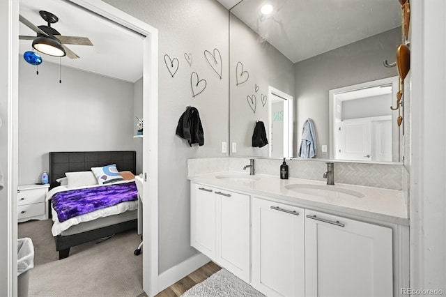 15547 W Vassar Ave, Lakewood, CO 80228 - bathroom with connected bathroom, double vanity, a ceiling fan, and backsplash