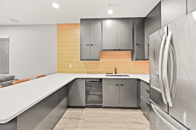 15547 W Vassar Ave, Lakewood, CO 80228 - kitchen with stainless steel fridge, gray cabinets, a peninsula, decorative backsplash, and recessed lighting